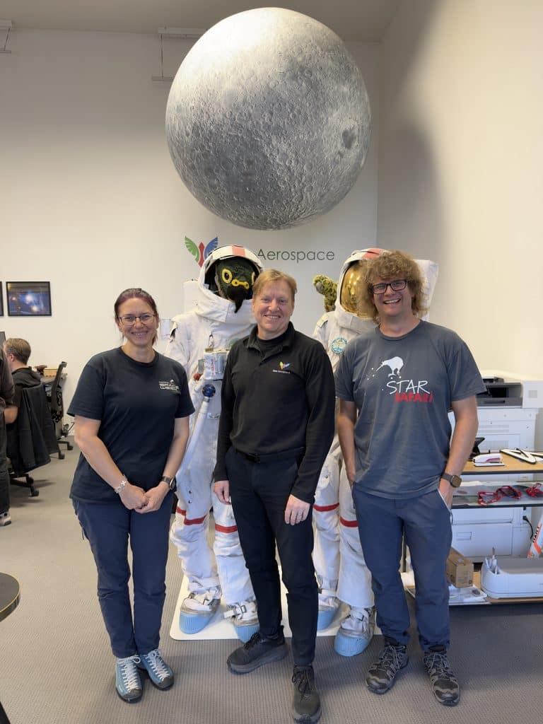Hari, Mark and Sam at Kea Aerospace, with a couple of astronaut suits behind them.